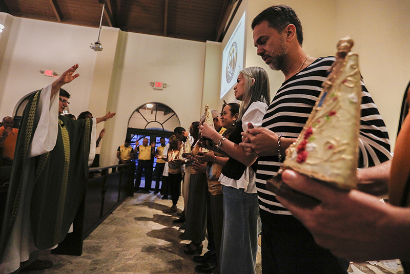 Representatives of each community hold blessed images of the C&iacute;rio of Nazareth as a Fr. Adelson Moreira blesses them during the launch of C&iacute;rio de Nazareth USA 2026 at Corpus Christi parish in Miami, on Saturday, June 18, 2026.