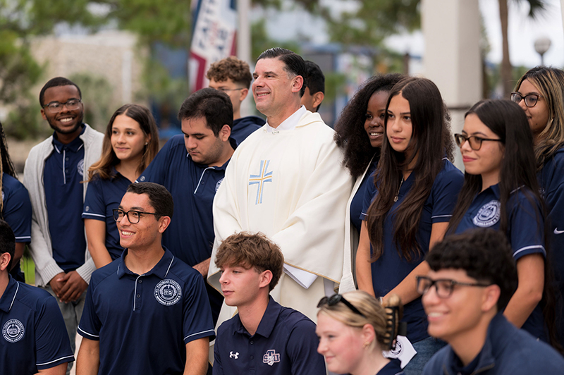 Father Raphael Capó , newly commissioned interim president of St. Thomas University in Miami, gathers with students there following a Sept 22 Mass on the Feast of St. Thomas of Villanova. Miami Archbishop Thomas Wenski presided at the Mass along with commissioning and reaffirmation of the university mission.