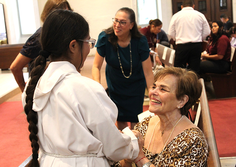 St. Michael the Archangel School former principal Carmen Alonso is greeted by a student prior to the Miami school's 75th anniversary Mass, celebrated by Archbishop Thomas Wenski, Sept. 20, 2026, at St. Michael the Archangel Parish.