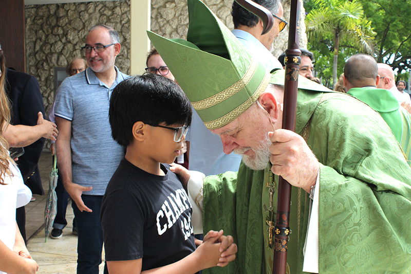A young parishioner from St. Michael the Archangel Parish in Miami speaks to Archbishop Thomas Wenski following the 75th anniversary Mass of St. Michael the Archangel School, Sept. 20, 2026.