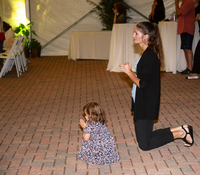 Michelle Lopez prays with her daughter Avila Marie during the Feast of Our Lady of Mercy Mass Sept. 24, 2026, at HCA Florida Mercy Hospital in Miami. As one of the founders, Lopez was present representing Los Momenticos, a nonprofit that sends care packages for families with sick children.