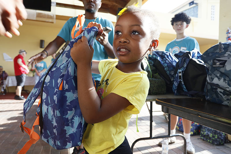 Matthew Butler, defensive tackle for the Miami Dolphins, greets families during a back-to-school outreach organized by the Matthew Butler Foundation at St. Helen Parish in Lauderdale Lakes, on Saturday July 25, 2026.The foundation distributed 600 backpacks filled with school supplies and food boxes to families at St. Helen in Lauderdale Lakes and St. Ann Mission in Homestead.