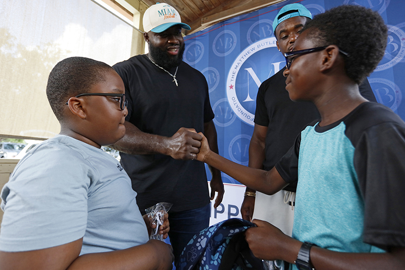 Matthew Butler, defensive tackle for the Miami Dolphins, greets families during a back-to-school outreach organized by the Matthew Butler Foundation at St. Helen Parish in Lauderdale Lakes, on Saturday July 25, 2026.The foundation distributed 600 backpacks filled with school supplies and food boxes to families at St. Helen in Lauderdale Lakes and St. Ann Mission in Homestead.