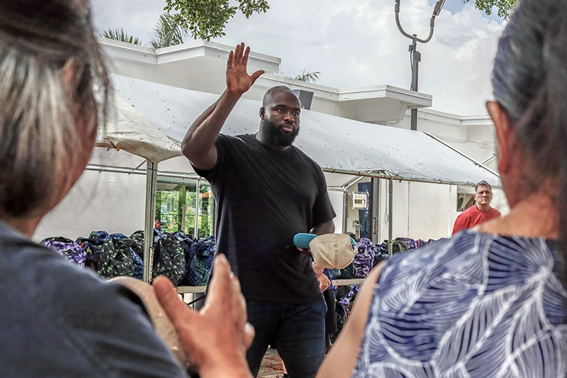 Matthew Butler, defensive tackle for the Miami Dolphins, welcomes families during a back-to-school outreach organized by the Matthew Butler Foundation at St. Ann Mission in Homestead on July 25. The foundation distributed backpacks filled with school supplies and food boxes to help children and families prepare for the new school year.