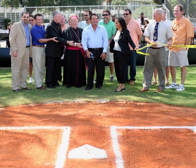 Cutting the ribbon on the new field, from left, front row: Alfredo Mesa, executive director of the Florida Marlins Community Foundation; newscaster and Curley alumnus Tony Segreto; Christian Brother Sean Patrick Moffett, Curley Notre Dame principal; Archbishop Emeritus John Favalora; John Quirino of Quirino Construction Co.; Catherine Bradley, executive director of Major League Baseball's Baseball Tomorrow found; and Curley Notre Dame baseball coach Jerry Yeash.