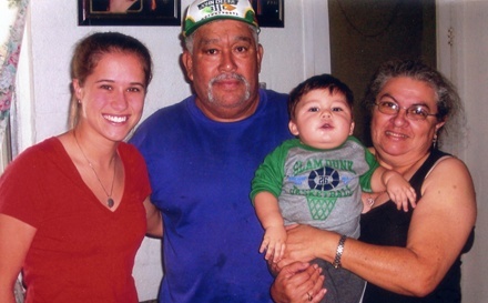 St. Thomas Aquinas student Natalie Sesto poses with Juan Carrillo, a Homestead farm worker, and a family from the community. St. Pius X Parish is still collecting long sleeve shirts for those who work in the fields of South Dade.