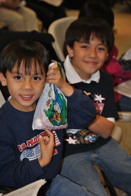 Sebastian and Ricardo Paiz excitedly hold up a bag of candy they received. Inside it were a cajeta de leche (milk-based caramel fudge), pineapple pastries, and cajeta de coco (coconut fudge), among other candies.