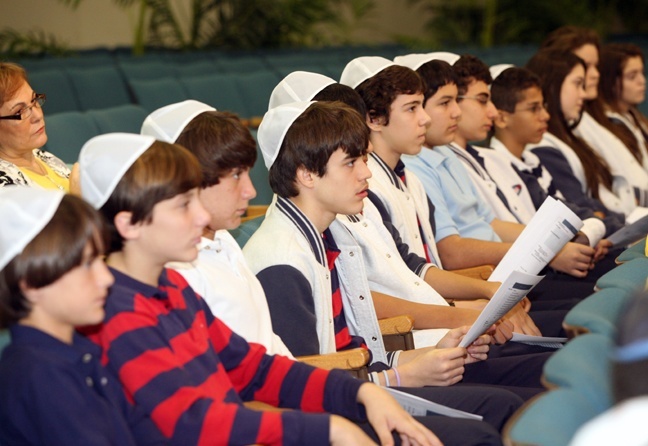 St. Hugh boys wearing yarmulkes listen to speakers welcoming them to Beth Torah Synagogue in Aventura Jan. 19.