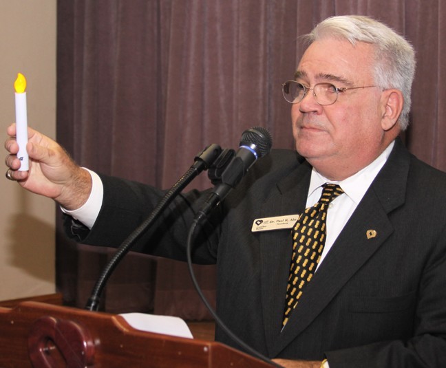 Paul R. Ahr, president and chief executive officer of Camillus House, holds up a candle and praises the work of the shelter's staff, volunteers and supporters. “May your glow warm us for as long as the poor are with us,” he said.