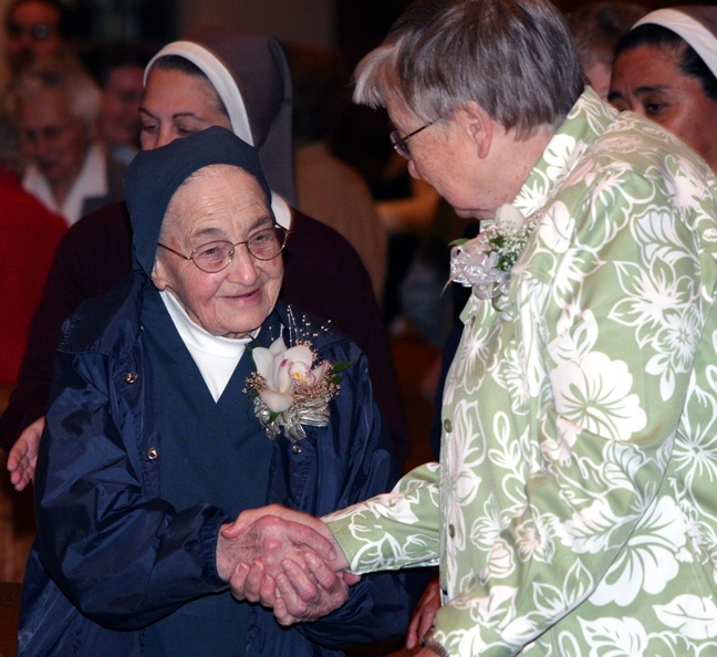 Diamond jubilarian Sister Francisca Jauregui, of the Daughters of Charity of St. Vincent de Paul, extends a sign of peace to golden jubilarian Sister Helen Faiver of the Adrian Dominicans during the annual Mass in honor of consecrated life Jan. 31.