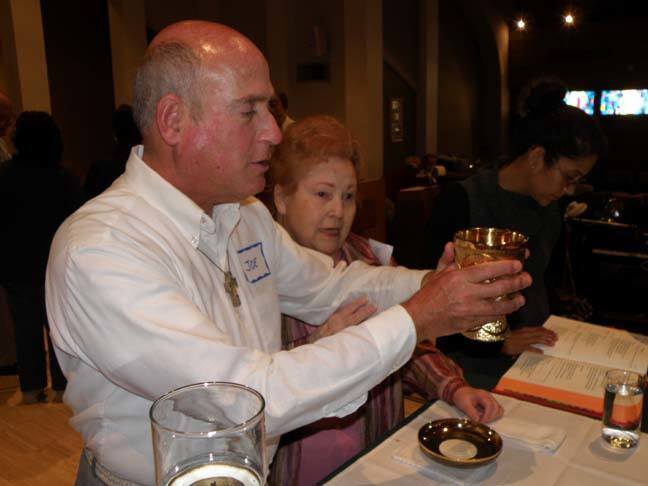 oe Palano, a St. Gabriel parishioner who is blind from birth, holds the chalice as fellow parishioner Rachelle Arsenault explains how the priest elevates it during Mass. The explanation of Mass for the blind and visually impaired was organized by Dolores McDiarmid, a local Catholic with a master's degree in pastoral ministries who has worked with the blind and visually impaired for more than 25 years.