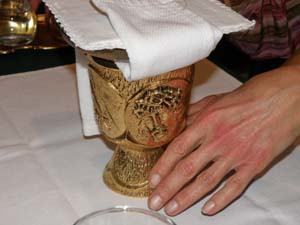 Nigel Ricards puts his hands on the chalice during the explanation of Mass for the blind and visually impaired that took place at St. Gabriel in February. The event was organized by Dolores McDiarmid, a local Catholic with a master's degree in pastoral ministries who has worked with the blind and visually impaired for more than 25 years.