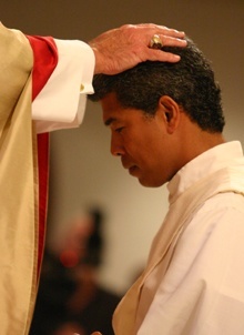 With the imposition of hands, Archbishop John C. Favalora ordains Jesus 'Jets' Medina as a priest of the Archdiocese of Miami.