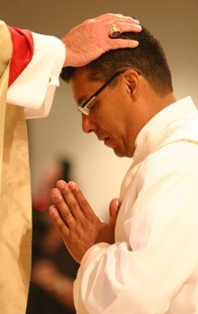 With the imposition of hands, Archbishop John C. Favalora ordains Giovanni Pe�a as a priest of the Archdiocese of Miami.