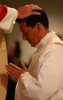 With the imposition of hands, Archbishop John C. Favalora ordains Armando Tolosa as a priest of the Archdiocese of Miami.