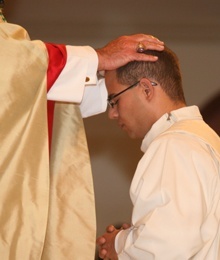 With the imposition of hands, Archbishop John C. Favalora ordains Luis Rivero as a priest of the Archdiocese of Miami.