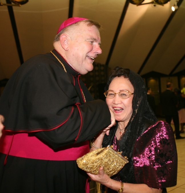 Archbishop Thomas Wenski greets Flossie Abrigo, a Filipino, after Mass.