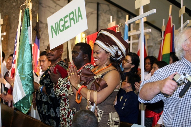 Adanma Osuji, a member of the Nigerian apostolate, applauds Archbishop Wenski as he enters St. Clement Church.