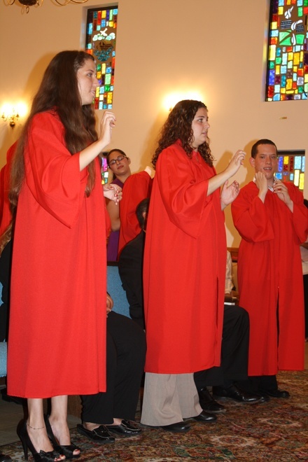 From left,Alexis Pena, Stephanie Pena and Arturo Bustos "sign" the Beatles' "Let It Be" for Bishop Noonan at the end of Mass.