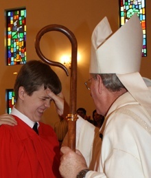 Patrick Goshgarian makes a face as he is anointed by Auxiliary Bishop John Noonan.