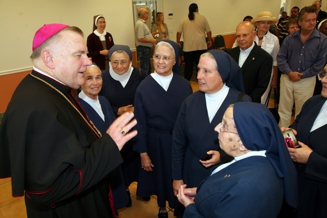 Archbishop Thomas Wenski chats with members of the Daughters of Charity after the Mass.