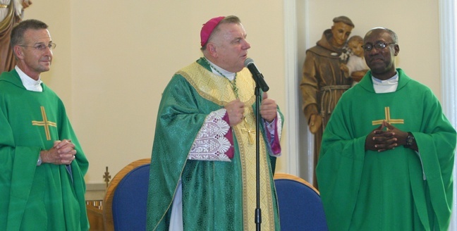 Archbishop Thomas Wenski addresses the congregation at St. Mary Star of the Sea in Key West. He spoke in English, Spanish, Haitian Creole, Polish and even a little Swahili. At left is Father John Baker, pastor of St. Mary Star of the Sea, and at right is his parochial vicar, Father Lesly Jean.