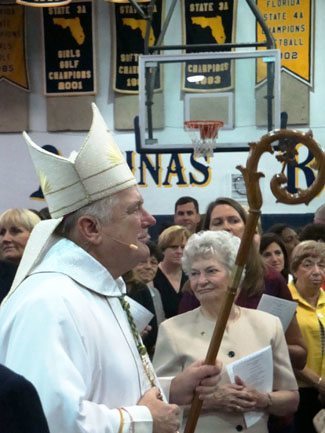 Archbishop Thomas Wenski processes towards the altar at the beginning of Mass in the capacity-filled St. Thomas Aquinas gym.