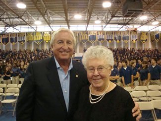 Dominican Sister John Norton and Frank Krauser, whose two children graduated from St. Thomas Aquinas High School, celebrate in the gym following the 75th anniversary Mass.