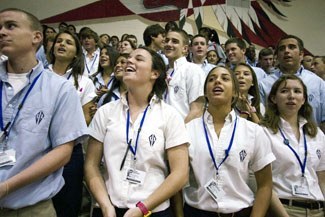 Sophomores Patricia Solenski, left, and Brittany Crouse, right, sing along with their classmates during the opening of school Mass marking Cardinal Gibbons High School's 50th anniversary.