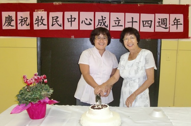 Bernadette Lee, current president of the Chinese apostolate, and May Agon, past president, cut the cake celebrating the group's 14th anniversary in the archdiocese.