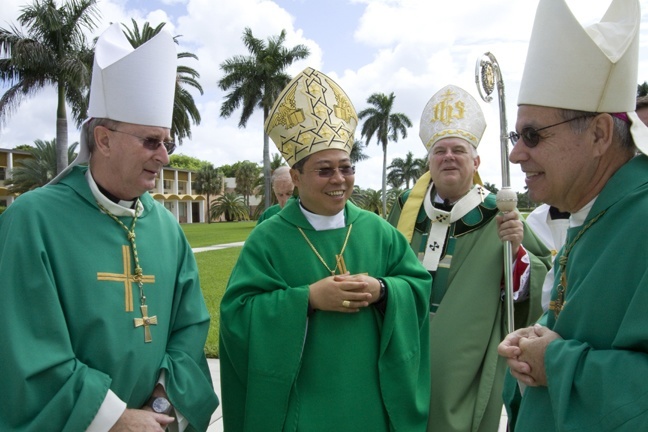 Archbishop Bernardito Auza, center, papal nuncio to Haiti, shares a laugh with Miami Auxiliary Bishop John Noonan and Felipe Estevez before entering St. John Vianney Seminary for the closing Mass of the Haitian Bishops Conference meeting. Behind them is Archbishop Thomas Wenski.