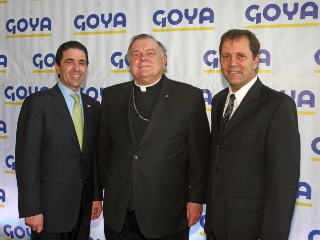 Frank Unanue, Archbishop Thomas Wenski and Tom Unanue pose for a photo at the new Goya facility in West Miami-Dade. The Unanues are descendants of the Spanish immigrants who founded the family-run business in 1936.