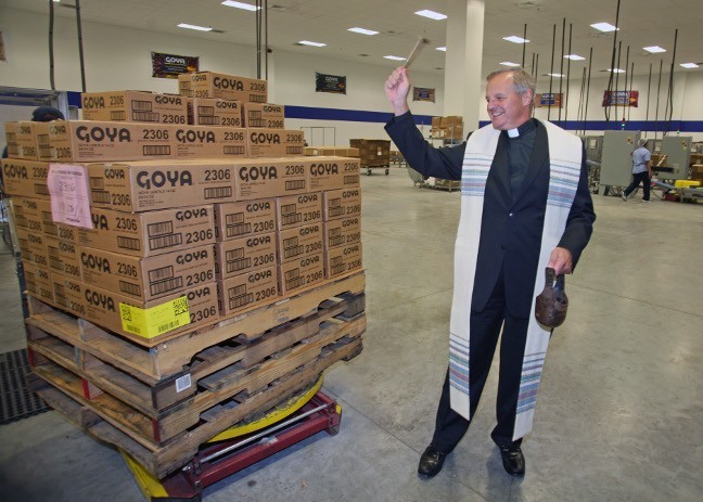 Msgr. Franklyn Casale, St. Thomas University president, blesses part of the warehouse at the new Goya facility in Doral.