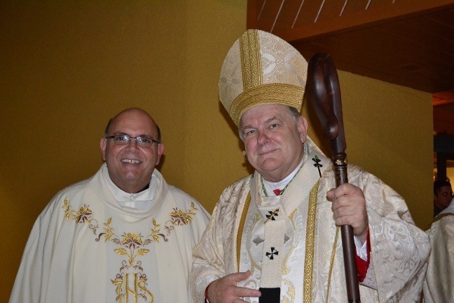 Father Fernando Heria, pastor, poses with Archbishop Thomas Wenski after the consecration of the new altar in the chapel of St. Brendan Church.