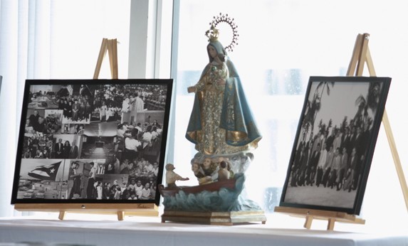 An image of Our Lady of Charity stands amid photographs of Pedro Pan children in the Miami camps that housed them until they could be reunited with their parents.