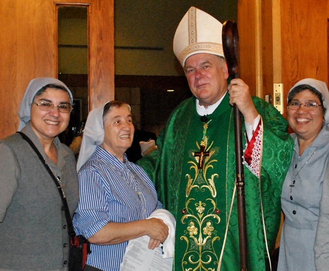 From left, Sister Ondina Cortes, Sister Carmen Alvarez and Sister Claudia Ortiz, three of the five Claretians working in the Miami archdiocese, pose with Archbishop Thomas Wenski after Mass.