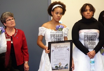 Barry University President Sister Linda Bevilacqua, Stephanie Wong, 17, holding a proclamation declaring Friday, Feb. 11, as College Bride's Walk Day, and Josie Ashton (Stephanie's mother), a victim's advocate, listen to the North Miami police chief address the audience before the Bride's Walk. North Miami Mayor Andre Pierre had just presented the proclamation to Sister Bevilacqua.