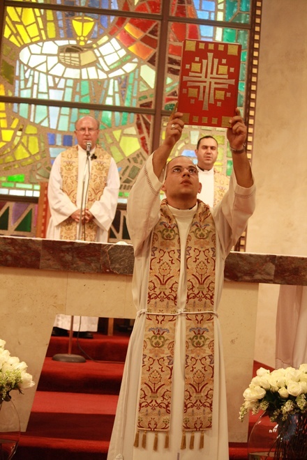 Father Luis Rivero, associate pastor at St. Agnes, prepares to proclaim the Gospel.