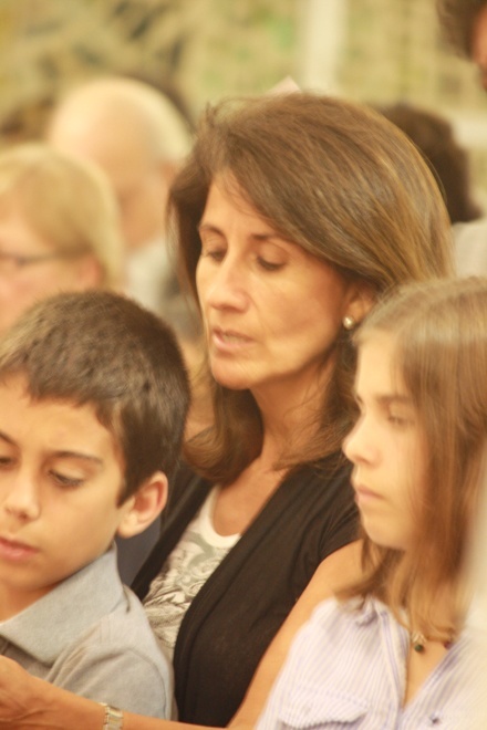 Members of the Arriba Cadania family -- Alvaro, Fatima and Macarena -- pray during the service.