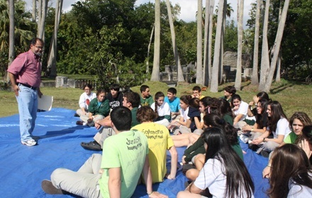 Teacher Danilo Recino, of Immaculata-La Salle's theology department, leads a group of students in their daily prayer experience at one of the campus' outdoor yards.