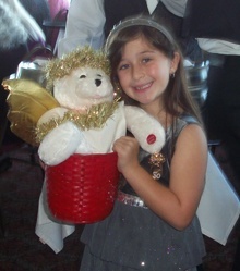 Alexa Petrillo, age 6, poses with singing Scarlett the bear. Guests pay ####_R_ to hear Scarlett sing, which raises money for the scholarship fund.