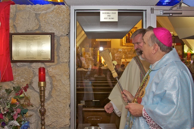 Archbishop Thomas Wenski blesses a plaque with the names of all the plane crash victims.