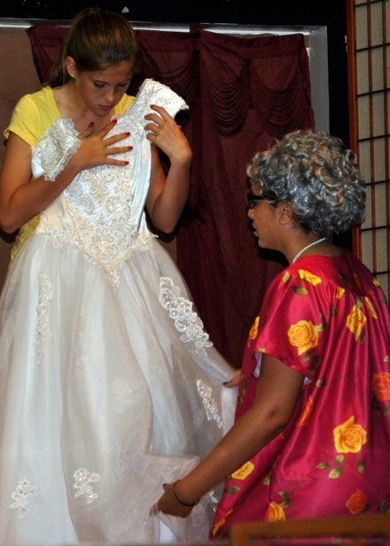 Carmen (Claudia Pe�as) holds a party dress made by her "abuela" in Sts. Peter and Paul School's "Que Pasa, USA?" production.