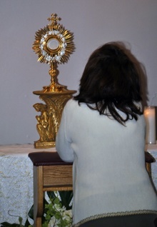 A participant at the Hispanic charismatic conference visits the Blessed Sacrament during a break in the program.