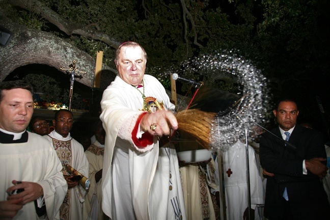Archbishop Wenski sprinkles holy water on the site where the Shrine of Our Lady of Perpetual Help will be built.
