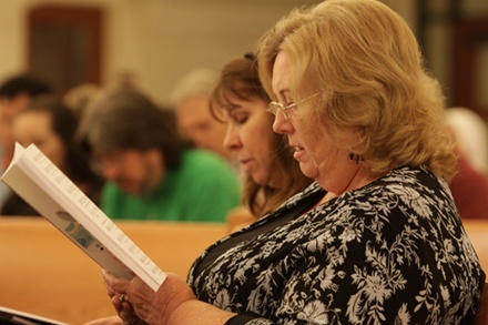 Kathy Myrick, left, and Dee Layman, who help prepare the liturgies at St. Thomas Aquinas High School in Fort Lauderdale, sing the Mass responses while following the music in one of the sample books now available for parish music directors.