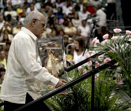 Luis Gutierrez, who smuggled the image of Our Lady of Charity out of Cuba 50 years ago, takes up another image of "cachita" as part of the offertory procession.