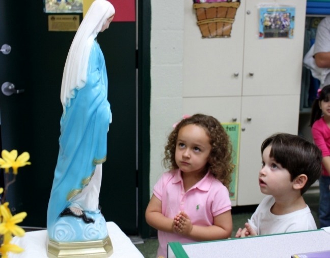 Elizabeth Braceras and Matthew Isaza, students at St. Kevin Catholic School’s Pre-K3A class, quietly pray to the Pilgrim Virgin in their classroom.