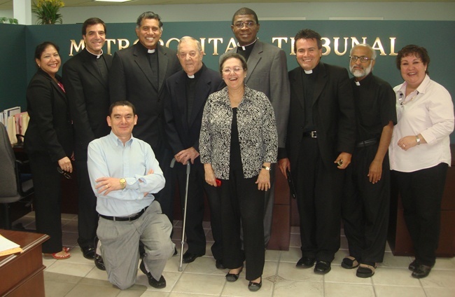 Father Jose Biain, fourth from left, poses with fellow members of the Tribunal staff, from left: Goretti Anthony, secretary; Msgr. Michael Souckar, adjutant judicial vicar; Roberto Aguirre, kneeling, case director; Father George Puthusseril, judicial vicar; Katia Arriaza, notary; Father Jude Ezeanokwasa, judge; Father Alvaro Pinzón and Father Mathew Thundathil, defenders of the bond; and Maite Lenoz, receptionist.