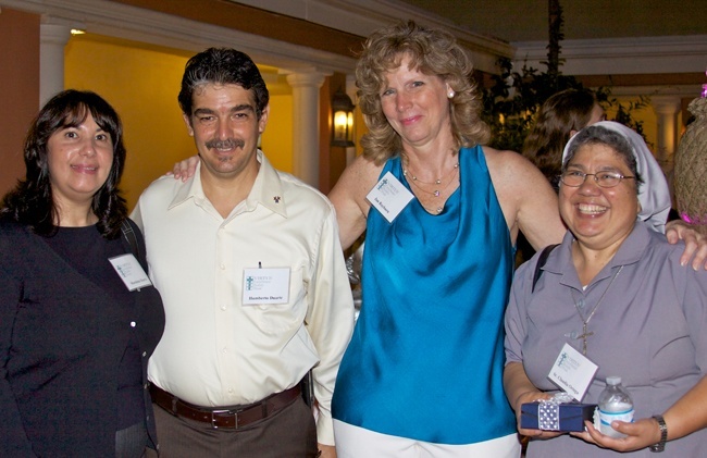 From left, Virtus training facilitators Moraima Duarte, her husband Humberto Duarte, and Sister Claudia Ortega, far right, of the Claretian Missionary Sisters, pose for a photo with Jan Rayburn, the archdiocese's Safe Environment coordinator, during the celebration that followed the Mass of appreciation for the facilitators.